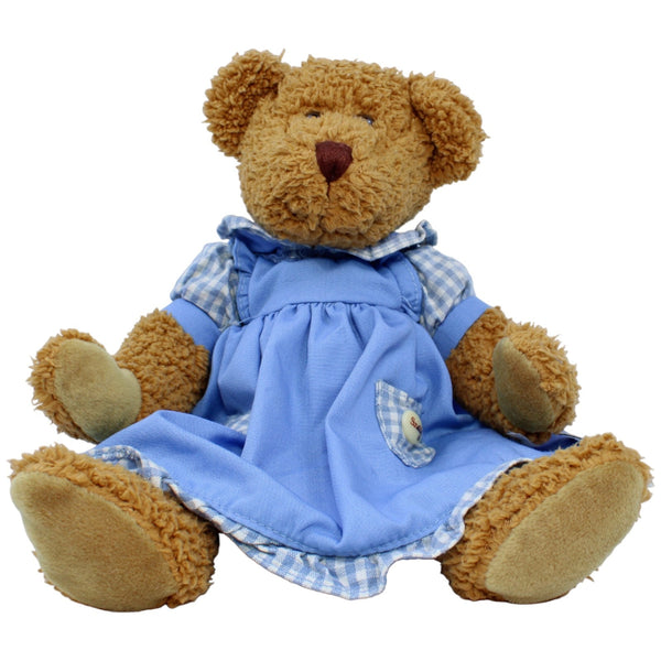 Teddybär in blauem Kleid, sitzend